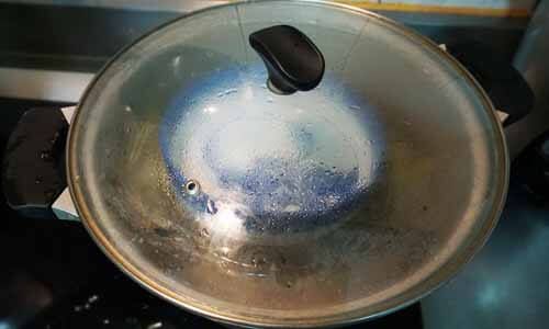用碗裝水壓住粽葉，不讓粽葉浮起