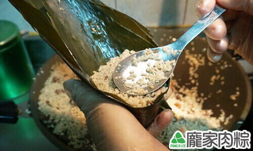 再用兩匙糯米蓋起來填滿粽子