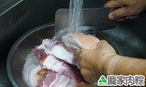用刀刮去豬皮上的髒汙
