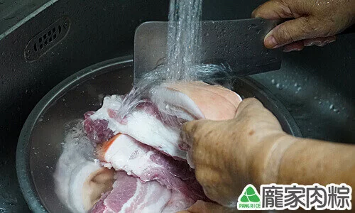 用刀刮去豬皮上的髒汙