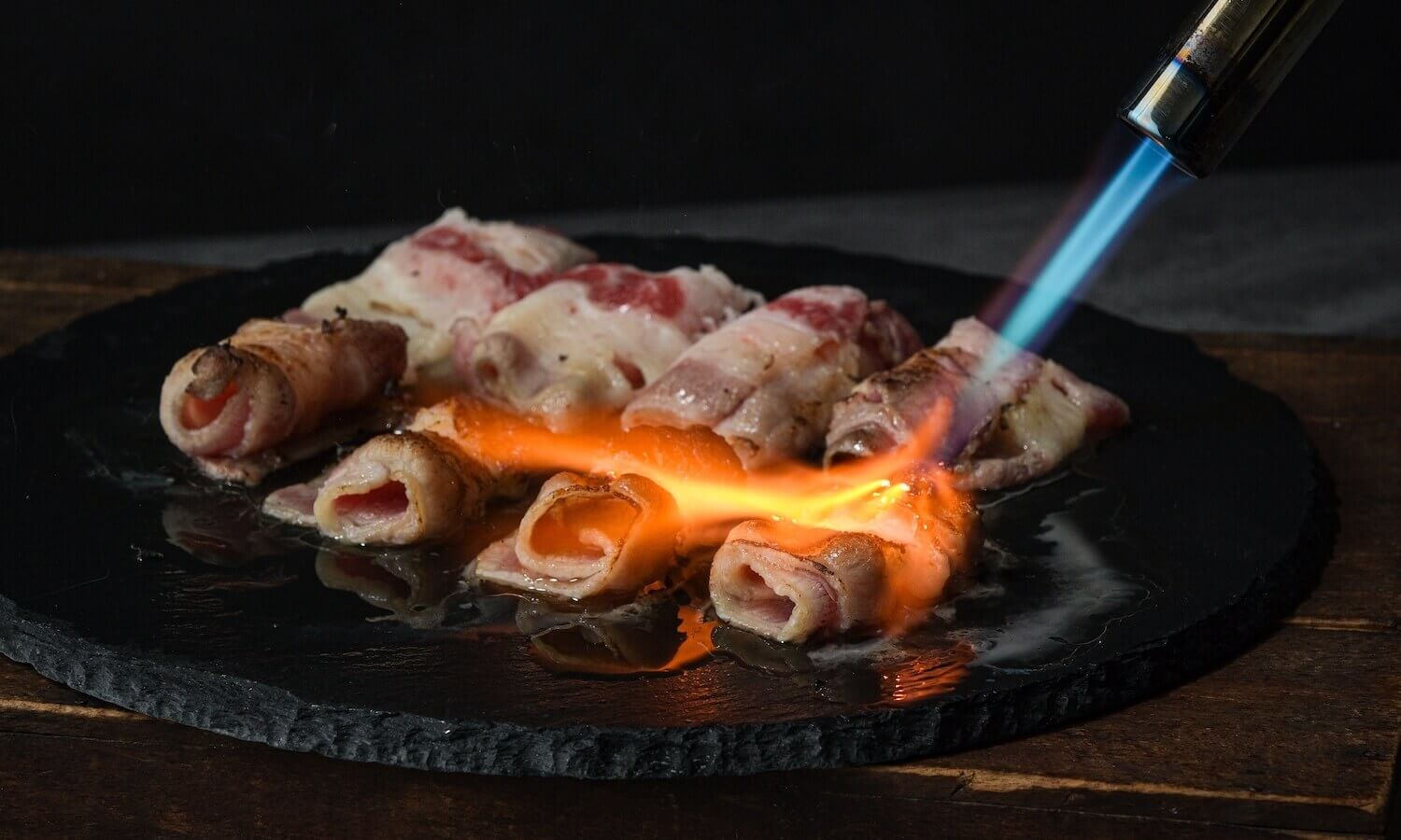 採用專業職人火槍炙燒技術，以180°C 的高溫瞬間炙燒牛五花，激發出牛脂與醬香並完美融合