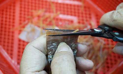 順著紋路將魷魚剪成一絲一絲的