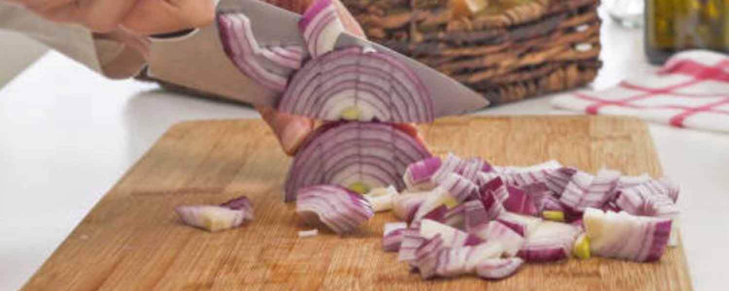 在木製砧板上切紅蔥頭